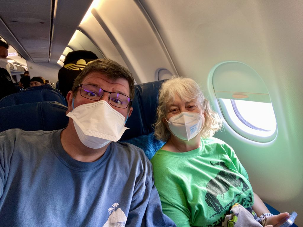 a man and woman wearing face masks on an airplane
