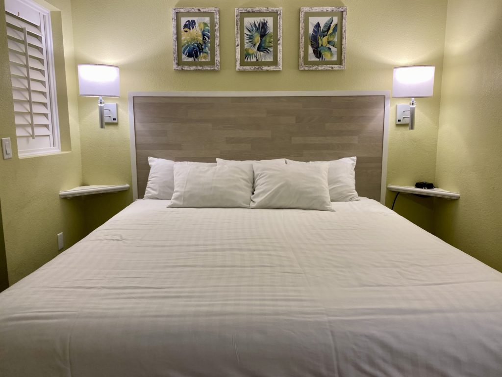 a bed with white sheets and pillows