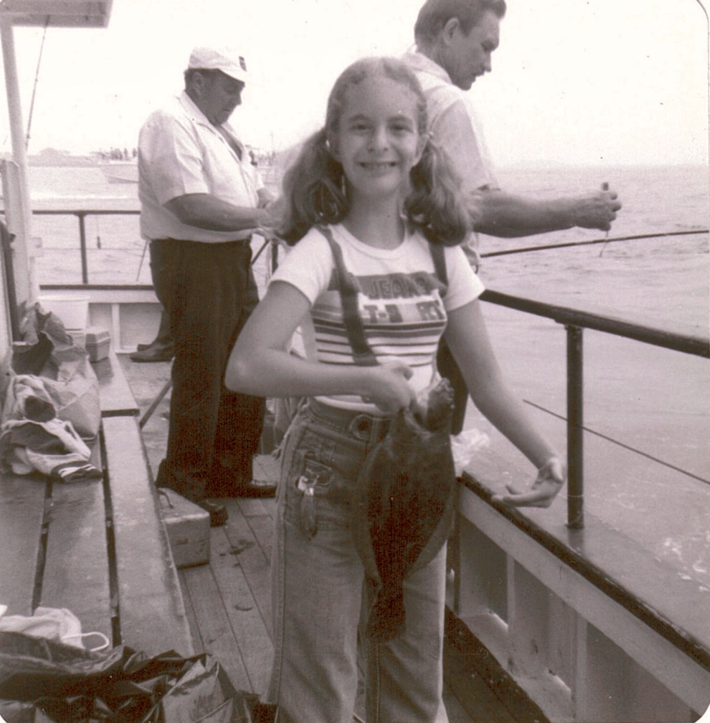a girl holding a fish on a boat