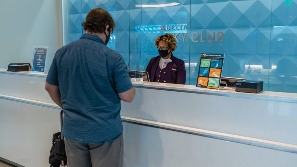 a man standing behind a counter with a woman wearing a face mask