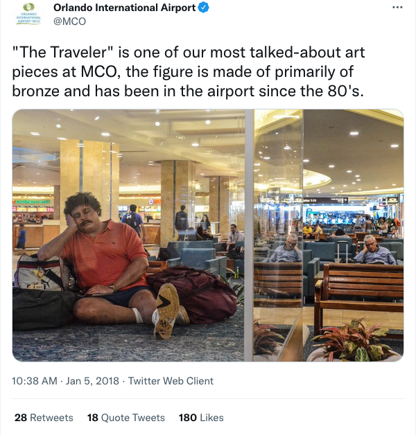 a man sitting on the ground in an airport