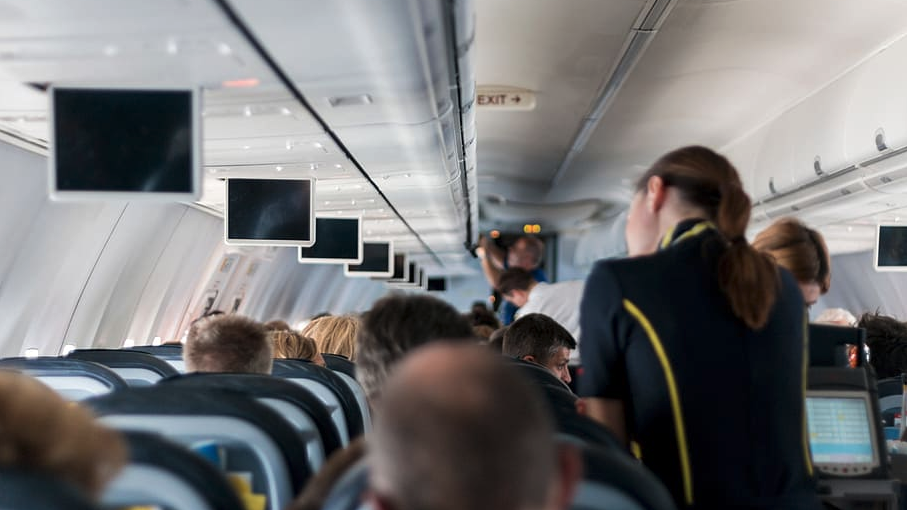 people in an airplane with people sitting on seats