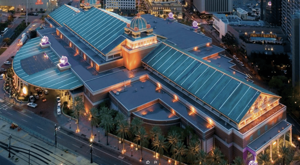 a building with a green roof and trees in front of it