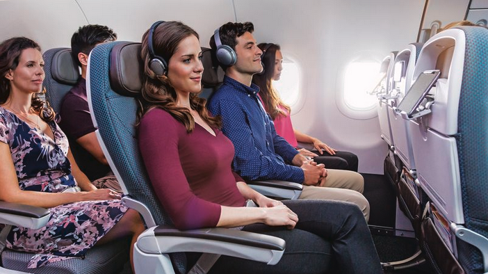 people sitting in a plane with headphones