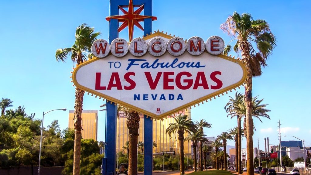 a sign with palm trees in the background with Welcome to Fabulous Las Vegas sign in the background