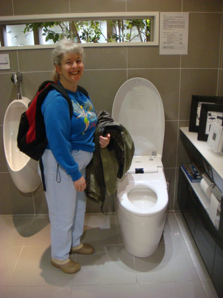 a woman standing next to a toilet