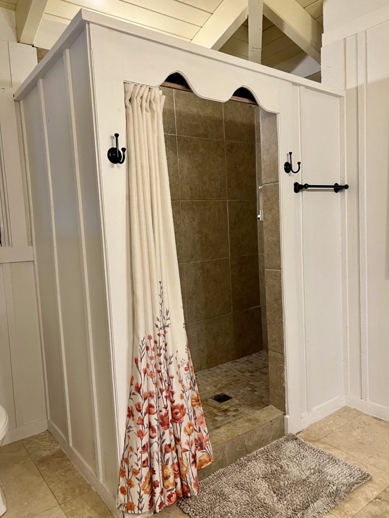 a shower with a floral curtain