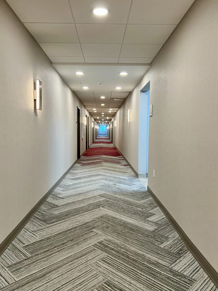 a long hallway with a carpeted floor and lights