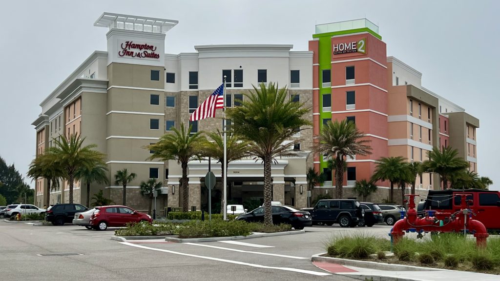 a building with palm trees and a flag