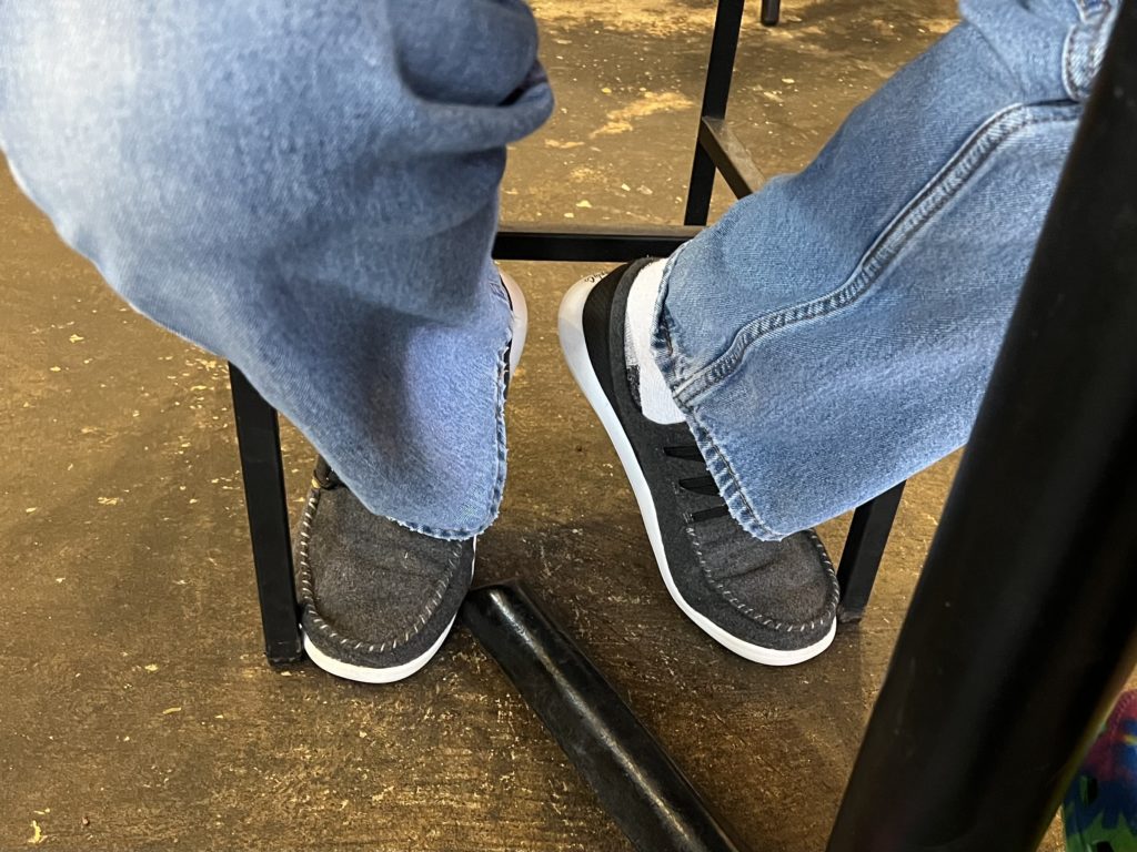 a person's legs and feet with jeans and shoes