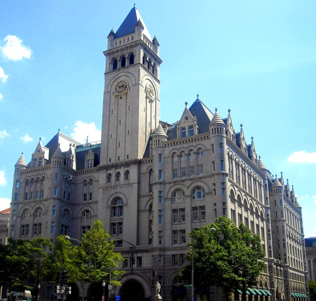 a large stone building with a clock tower with Old Post Office Pavilion in the background