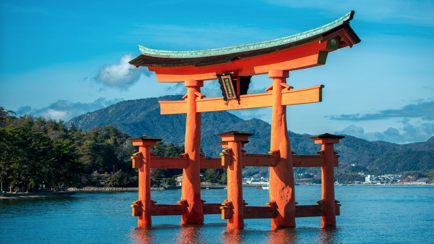 a structure in the water with Itsukushima in the background