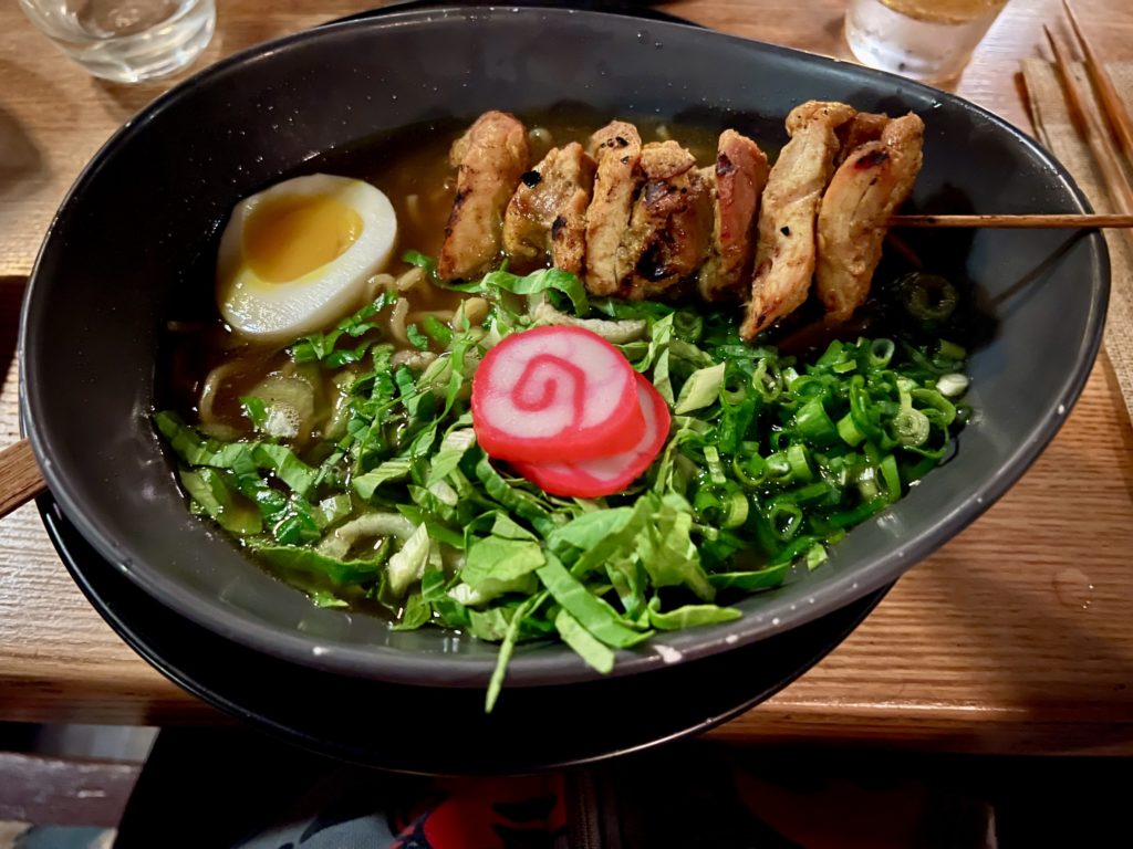a bowl of ramen with meat and vegetables