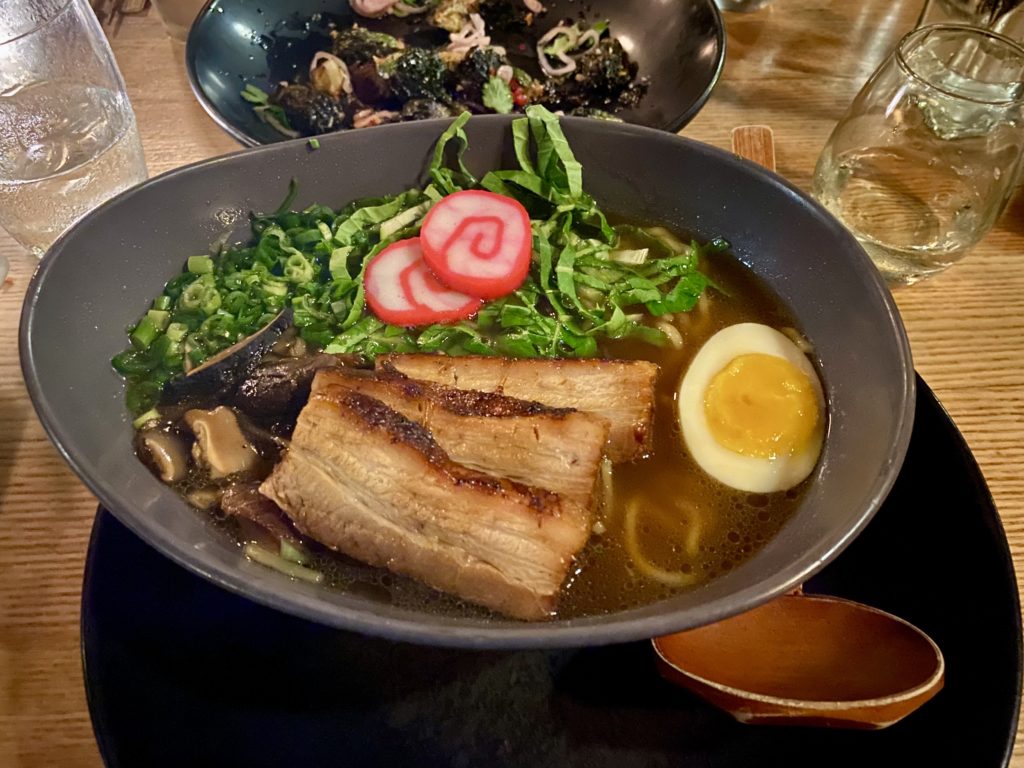 a bowl of ramen soup with meat and vegetables