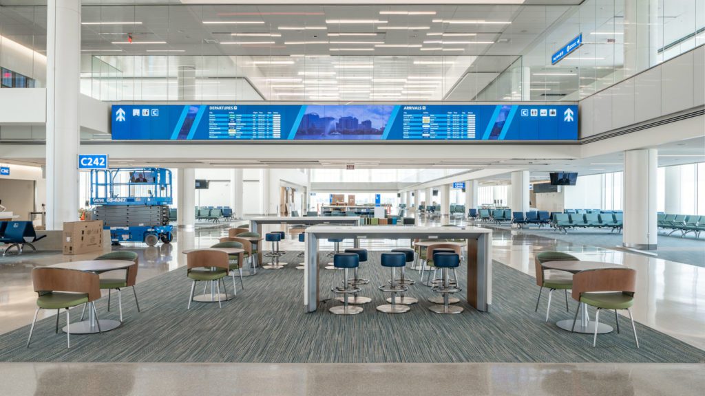 a large airport lounge with tables and chairs