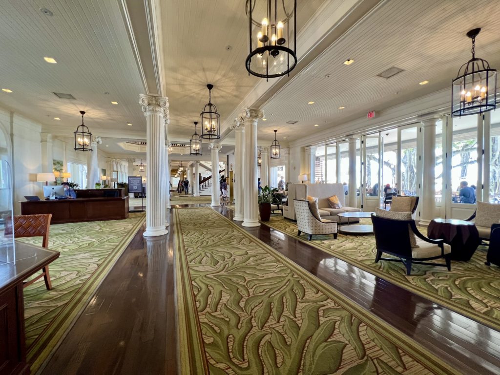 a large lobby with white pillars and green carpet