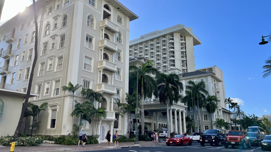 a group of buildings with palm trees and people walking on the street