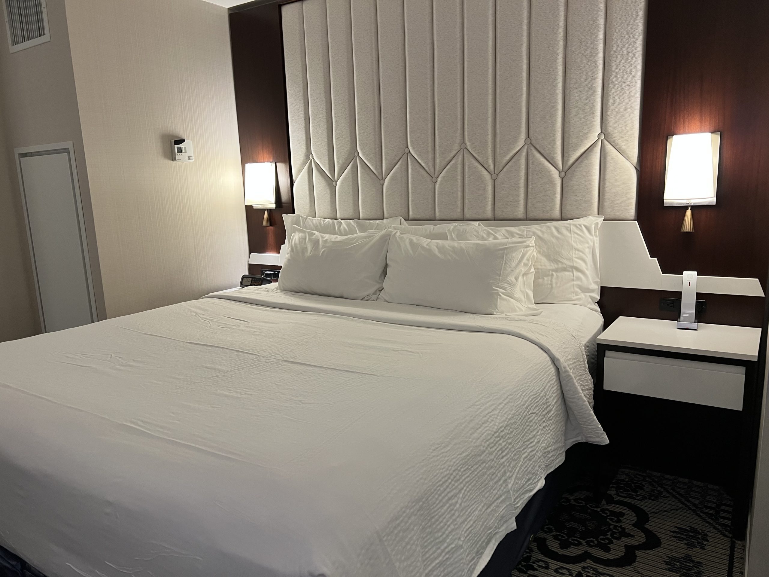 a bed with white sheets and pillows