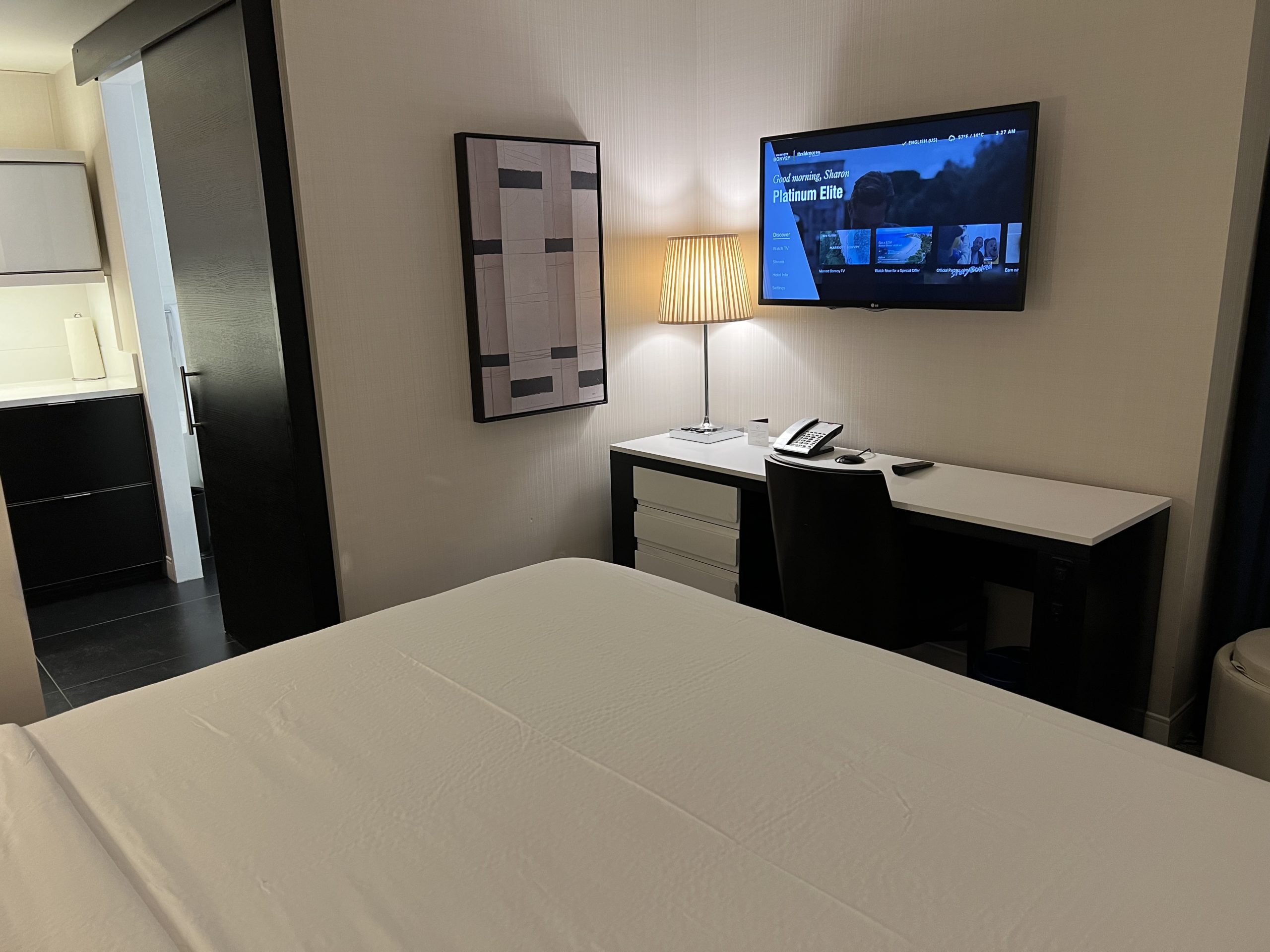 a bed with a desk and a tv on the wall