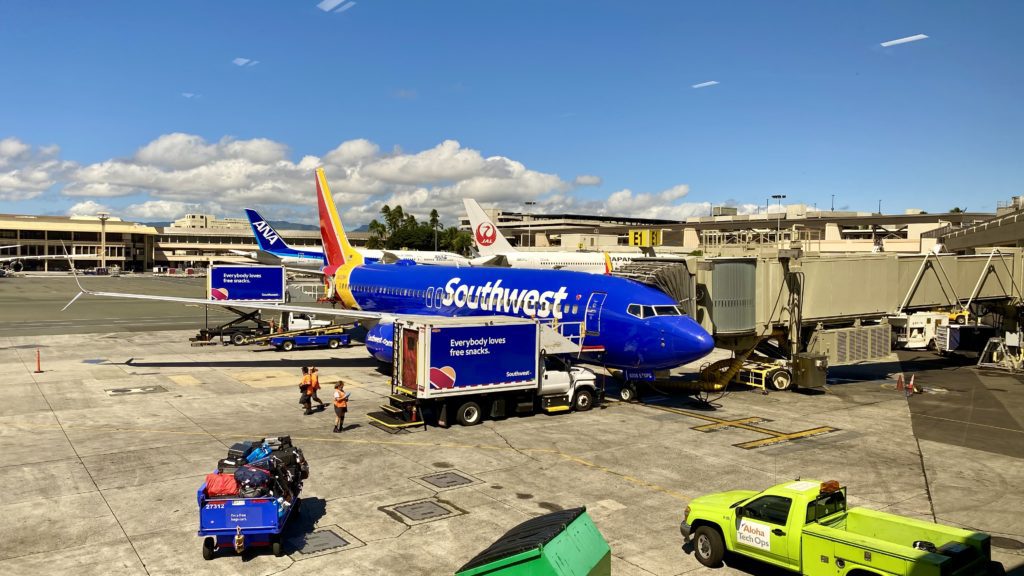 a blue airplane parked in a terminal