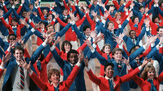 a group of people in red and blue uniforms raising their hands