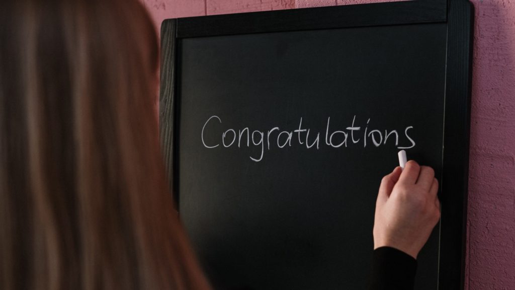 a person writing on a chalkboard