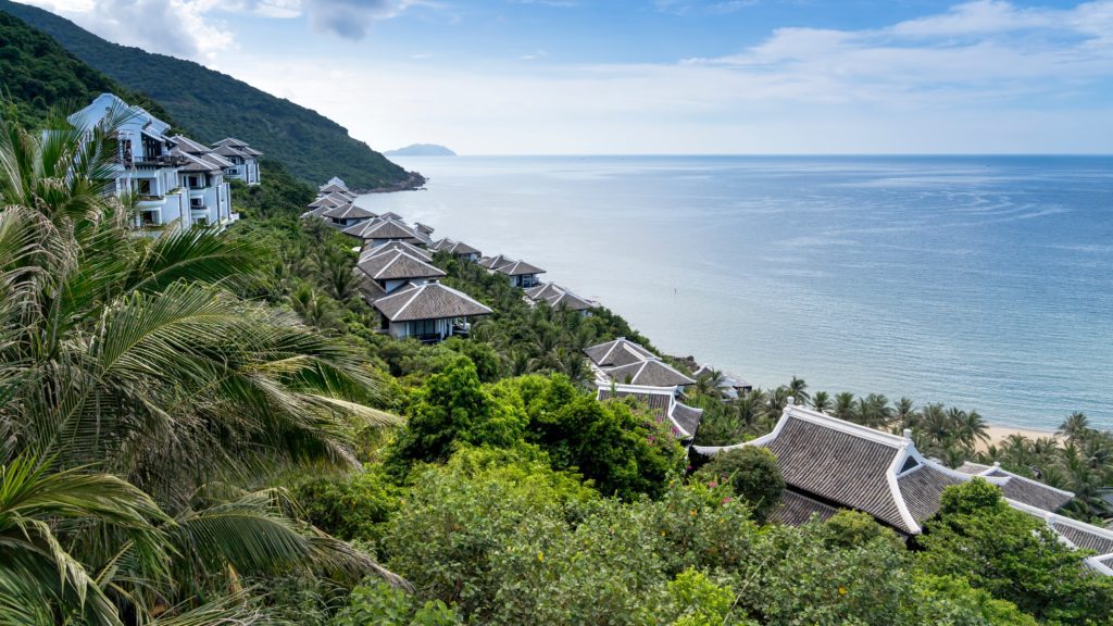 a group of buildings on a hill next to a body of water