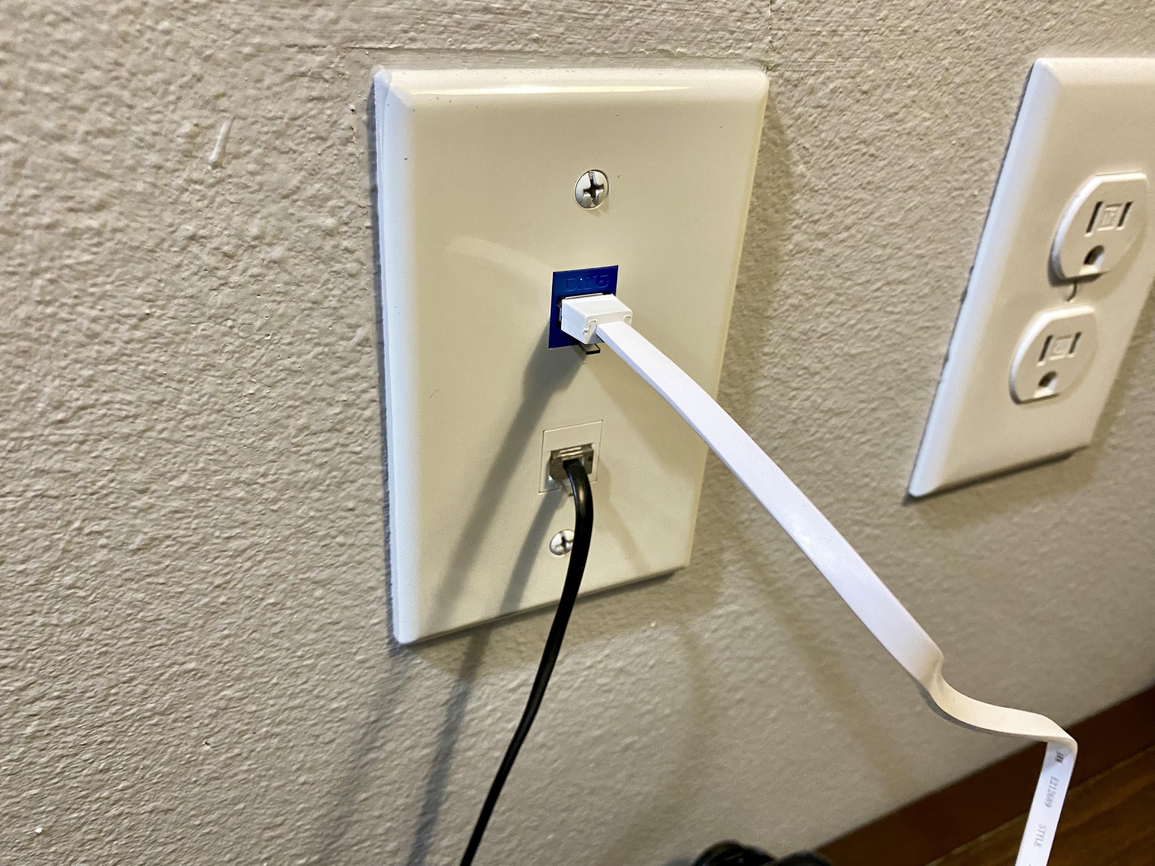 a white electrical outlet with a cable plugged into it