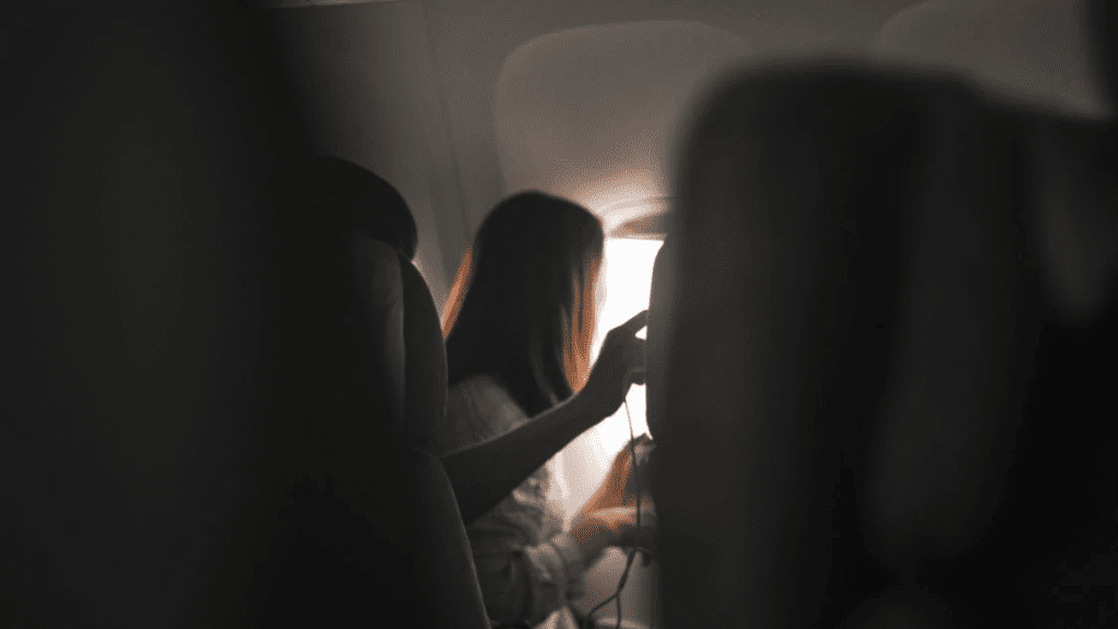 a woman using a device in an airplane