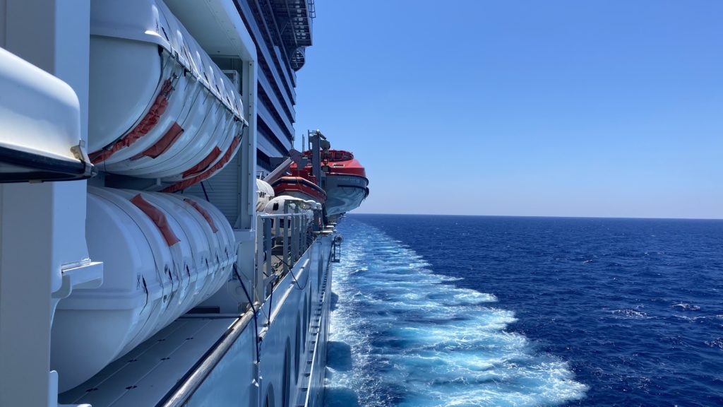 a cruise ship with a boat on the water