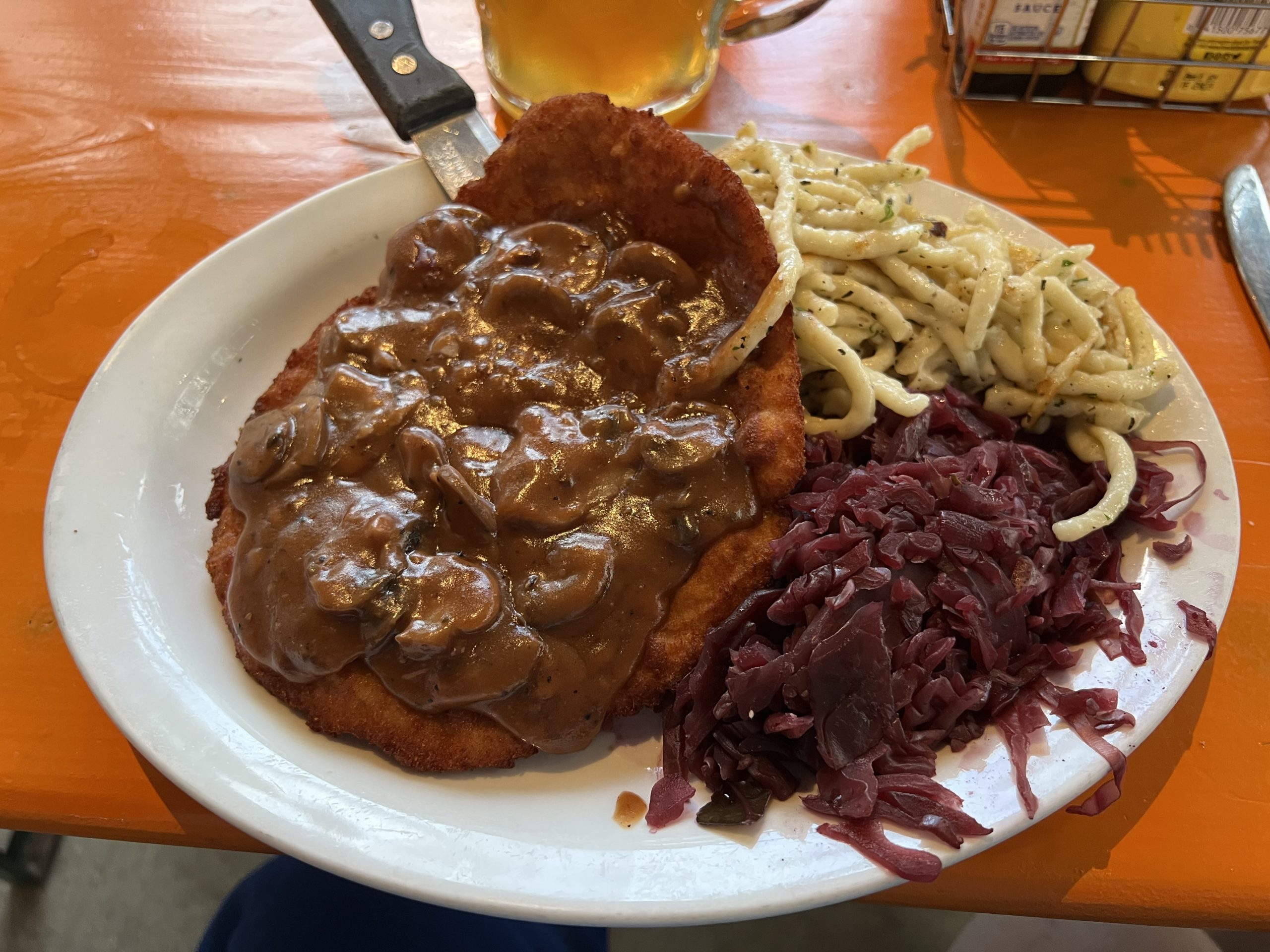a plate of food with a fork and a glass of beer