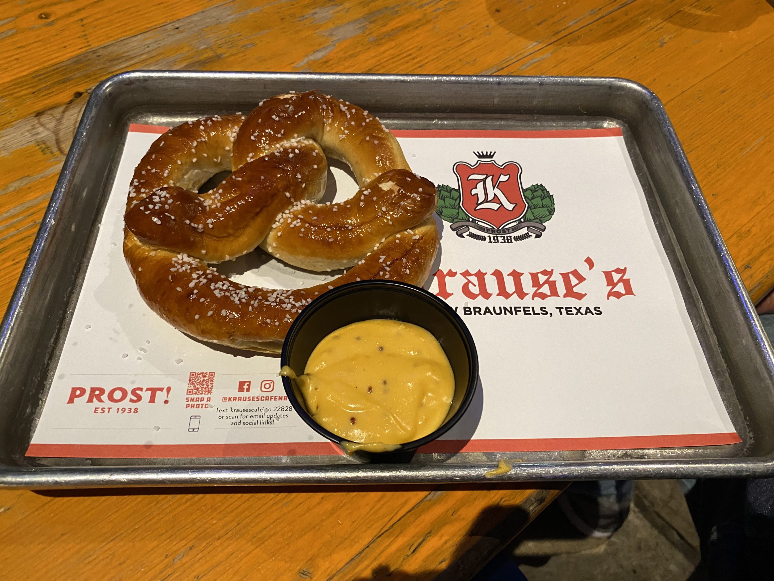 a pretzel and a bowl of mustard on a tray