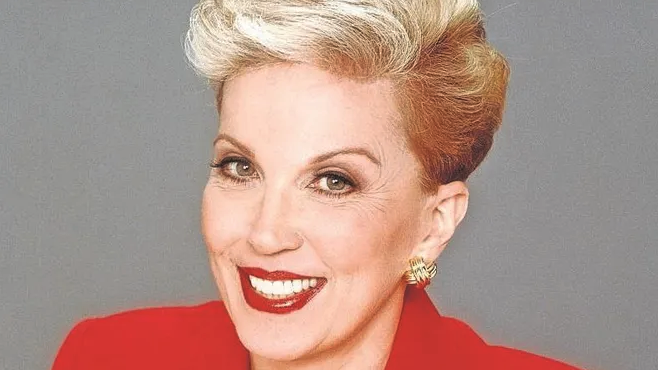 a woman with short blonde hair and red lipstick smiling