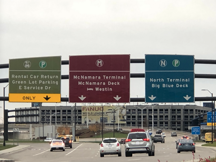 a road sign with cars driving on the road