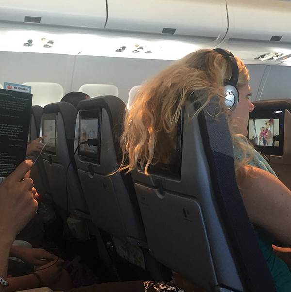 a woman sitting in an airplane with headphones on