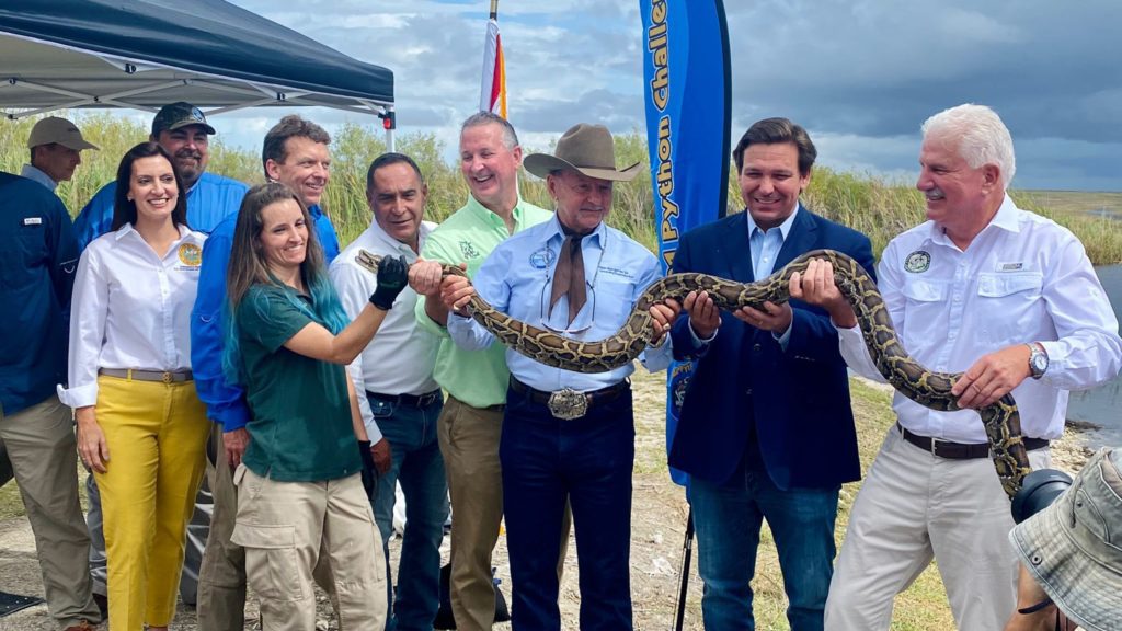 a group of people holding a snake