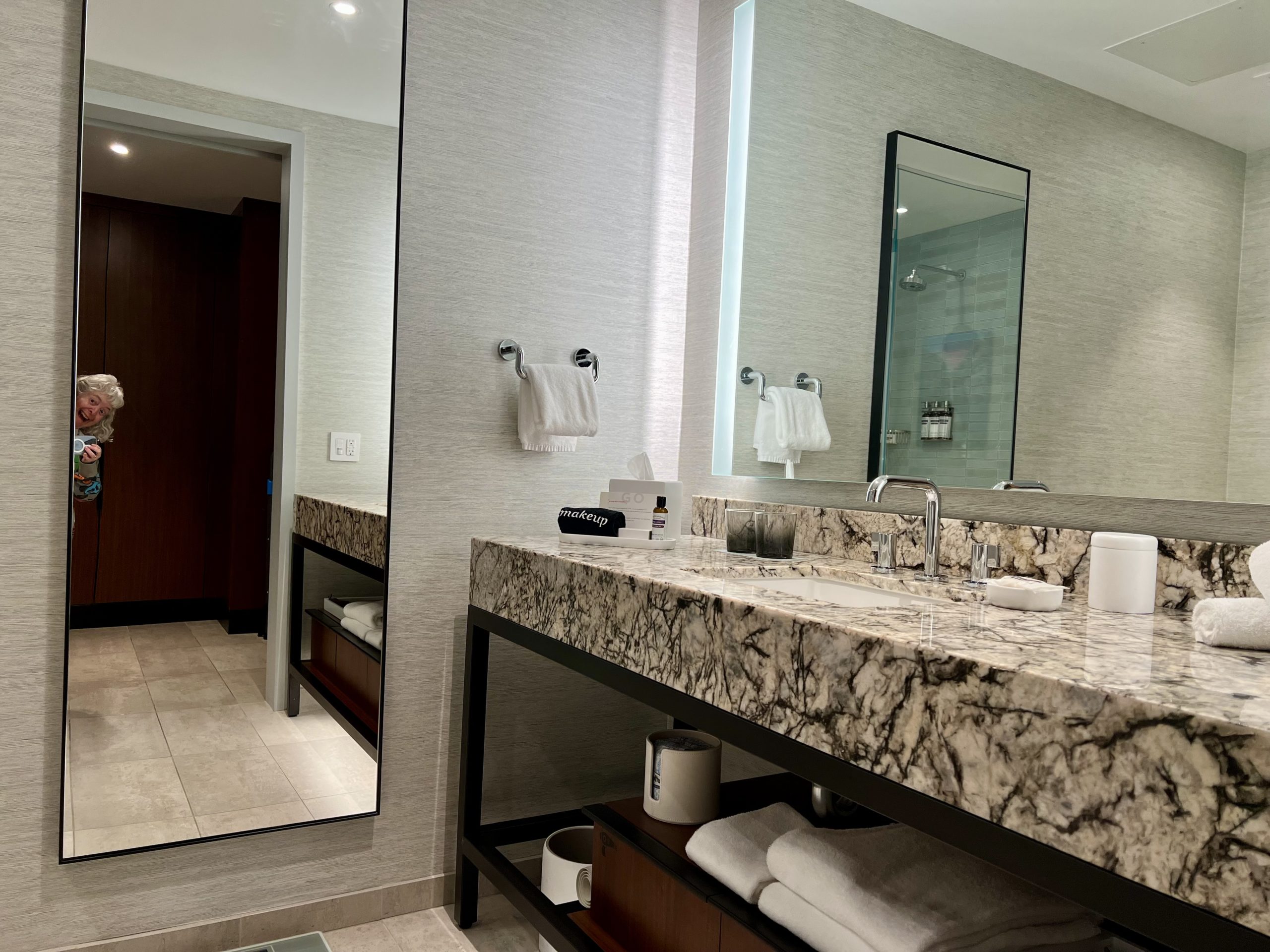 a bathroom with a marble countertop and a large mirror