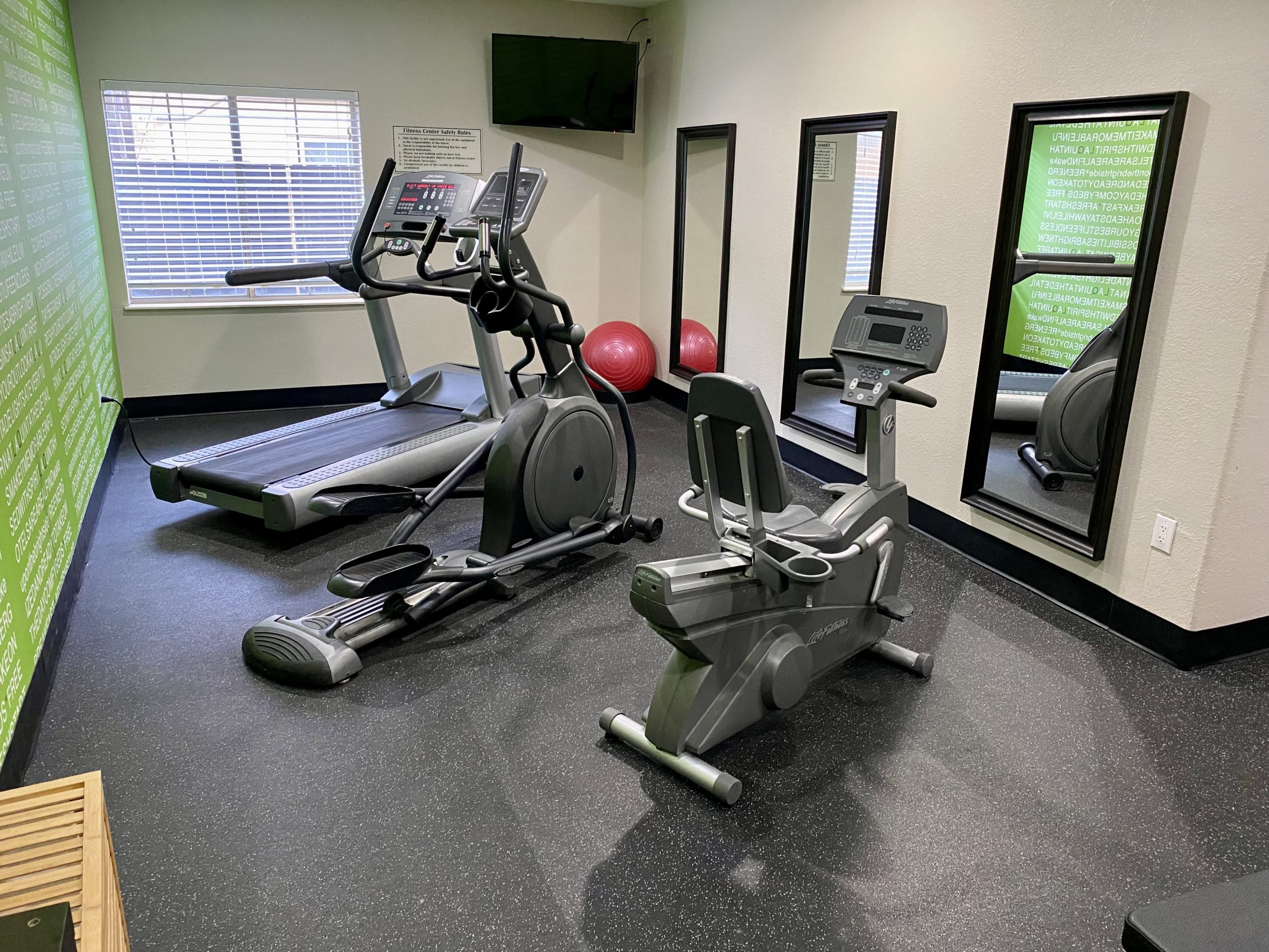 a room with exercise machines and a mirror