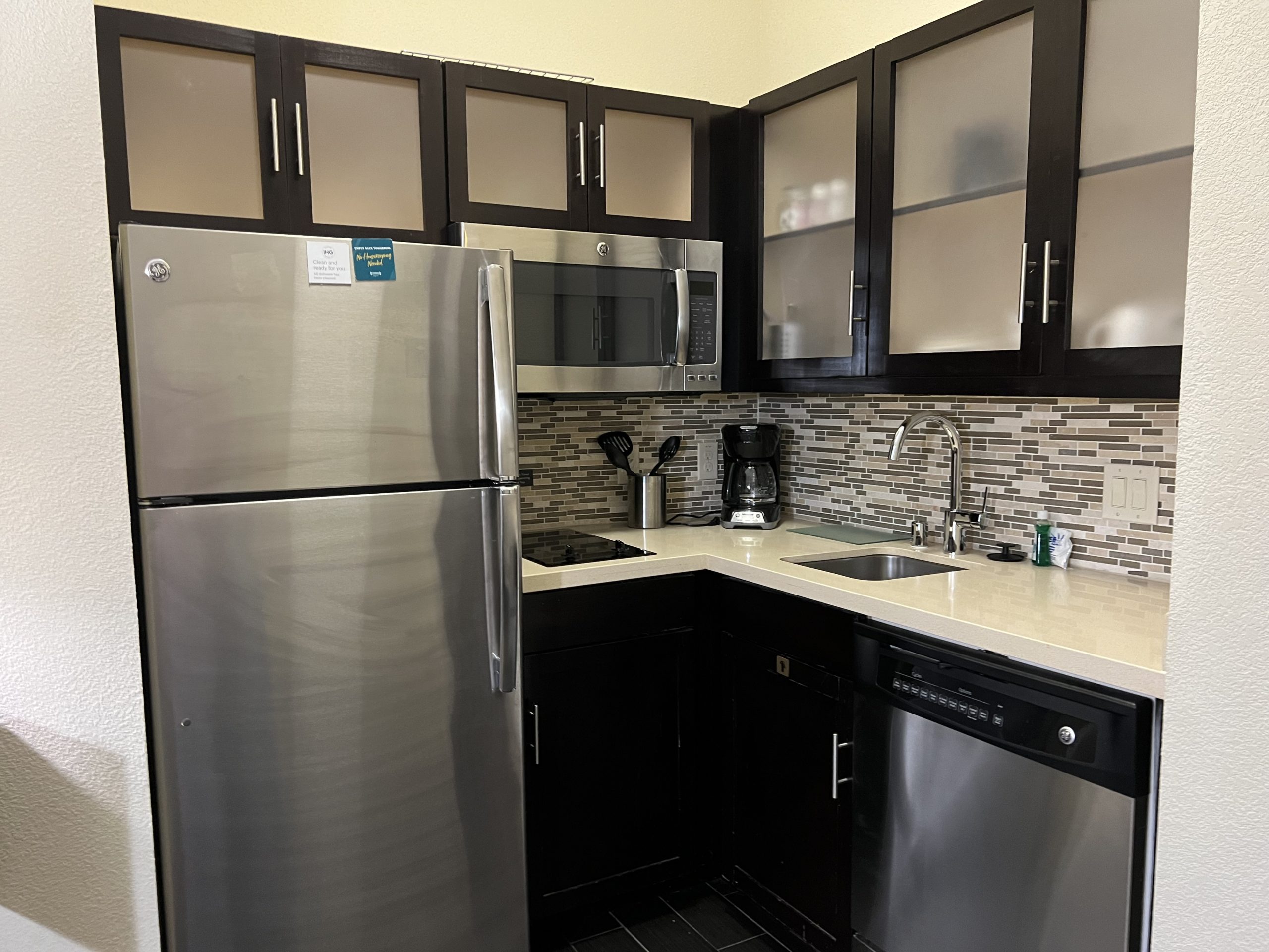 a kitchen with black cabinets and stainless steel appliances