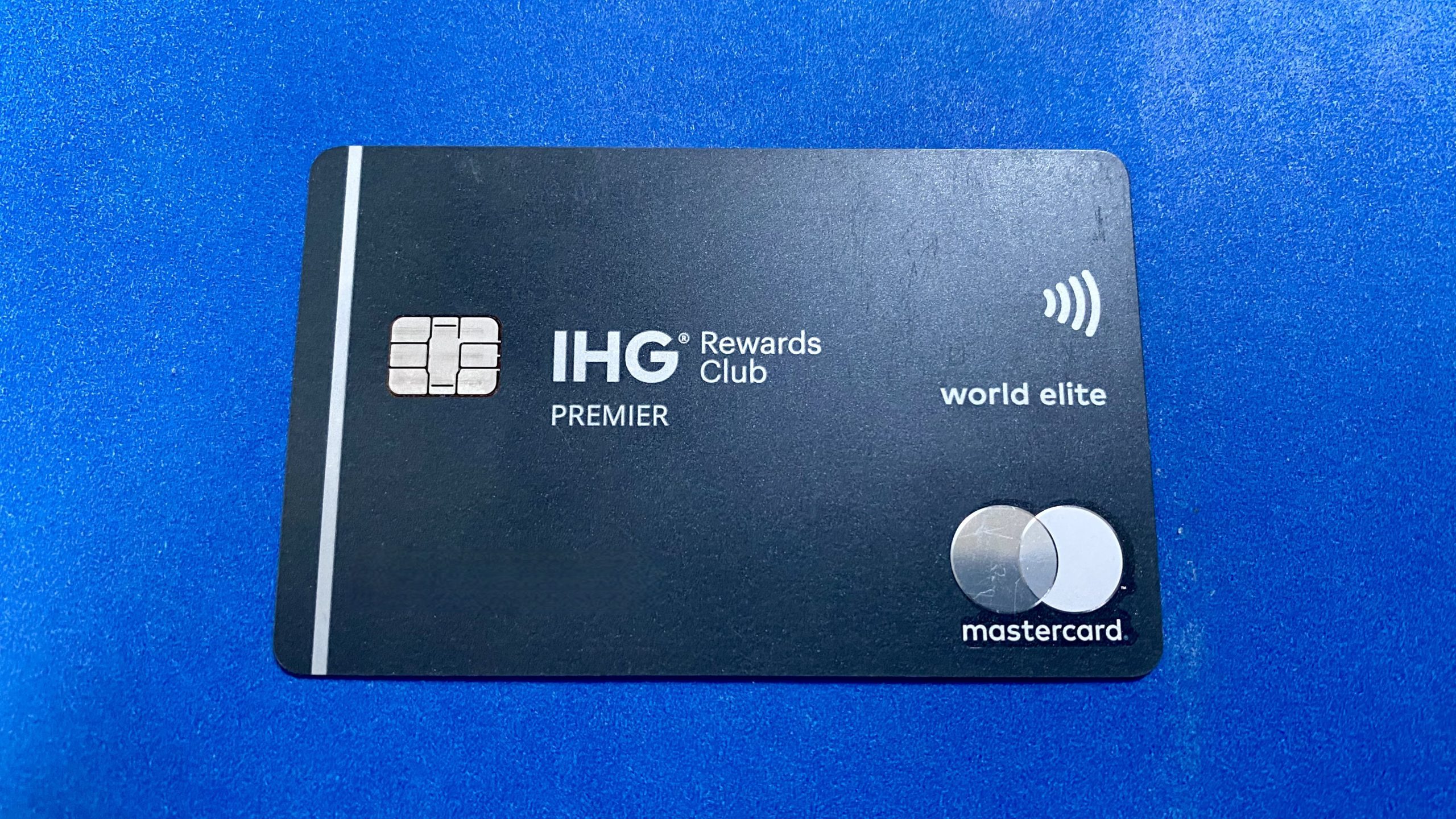 a black credit card with white text and silver circles