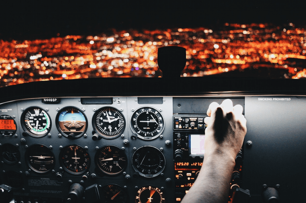 a hand on the control panel of a plane