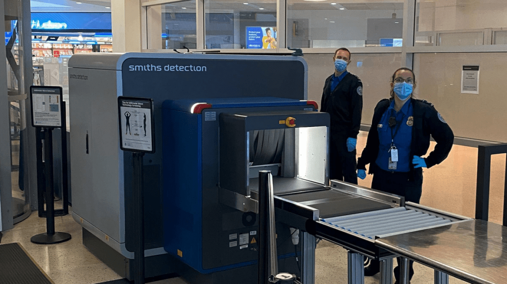 a group of people standing next to a machine