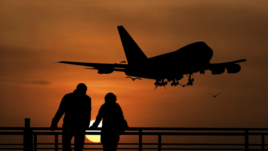 silhouette of people looking at an airplane