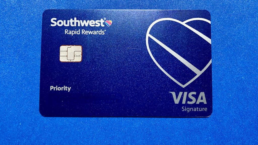 a blue credit card with a white heart and a white logo