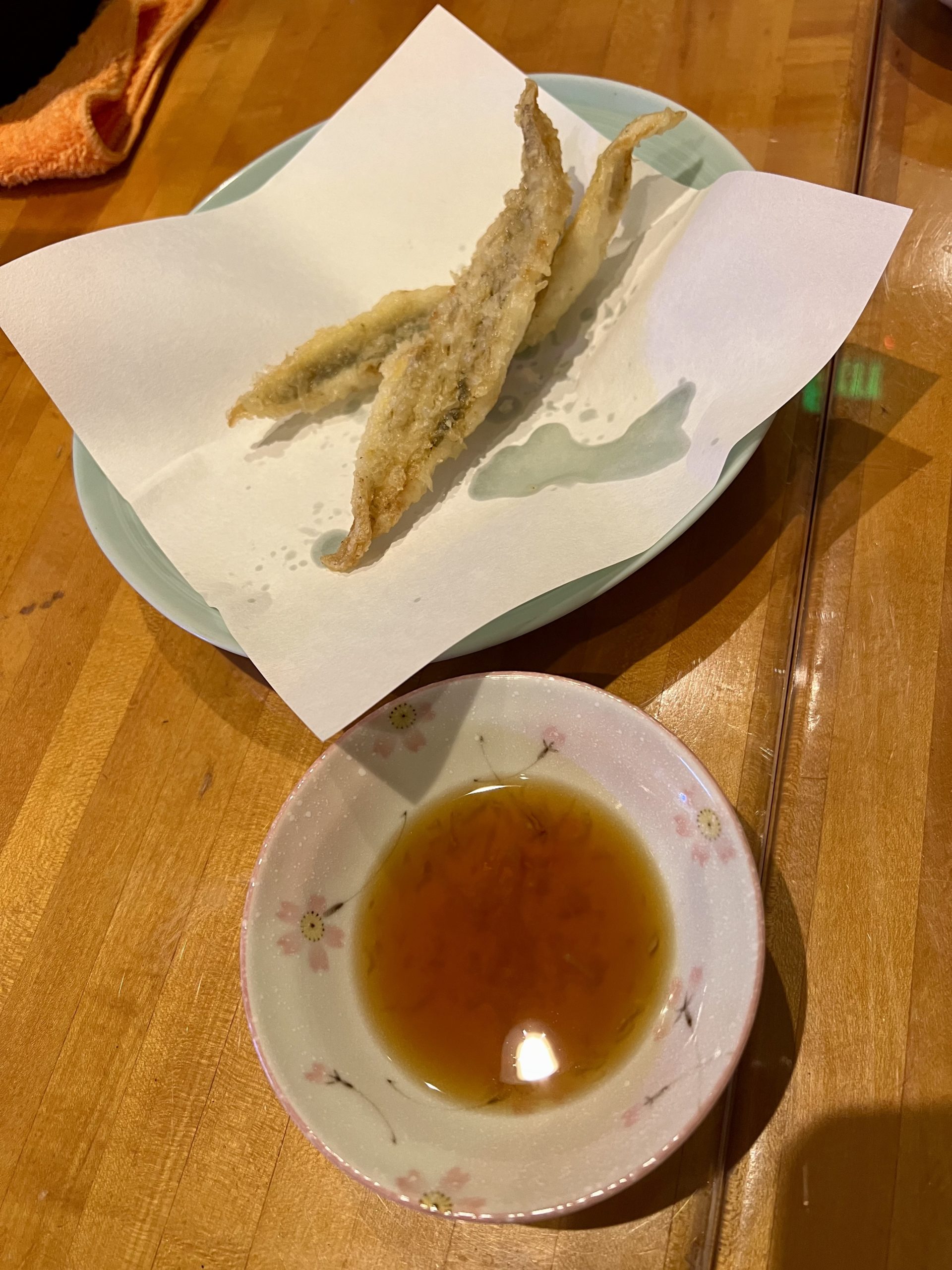 a plate of fried fish and a bowl of sauce