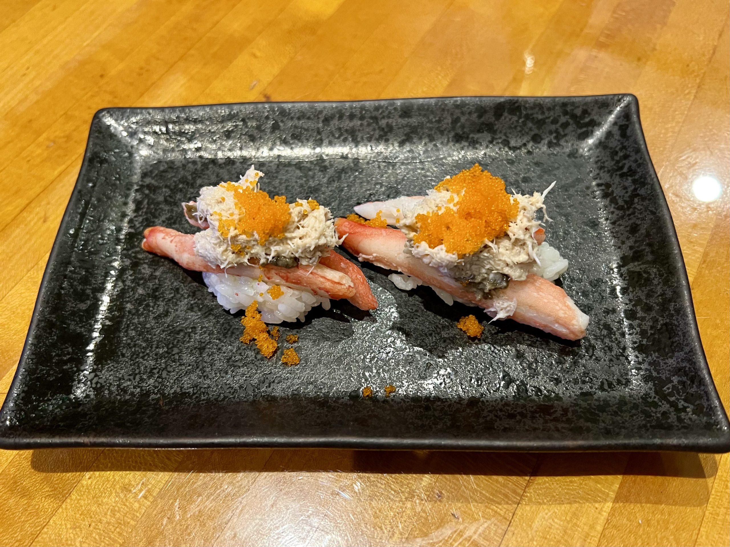 a plate of sushi on a wood table