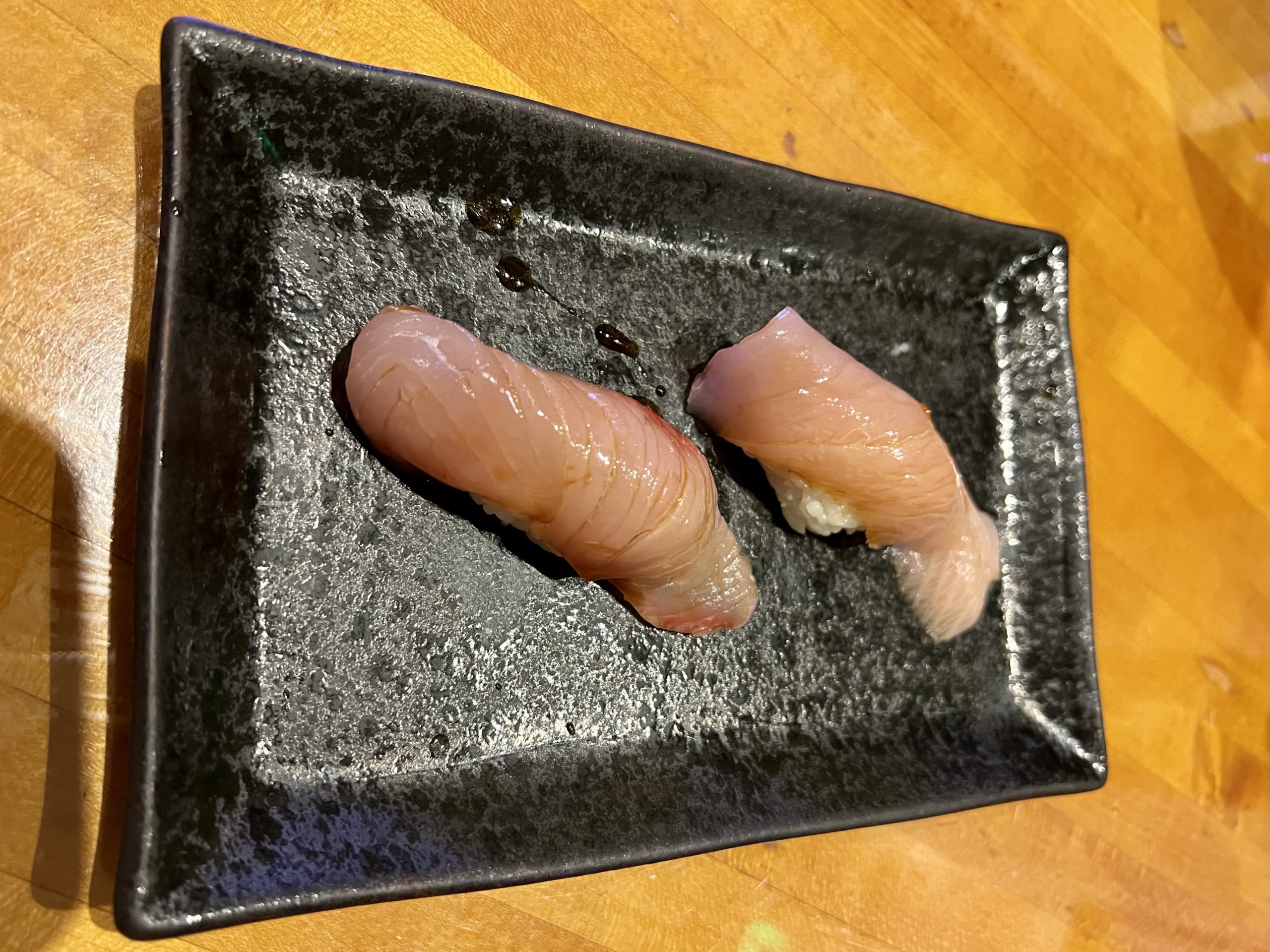 a plate of raw fish on a wood surface