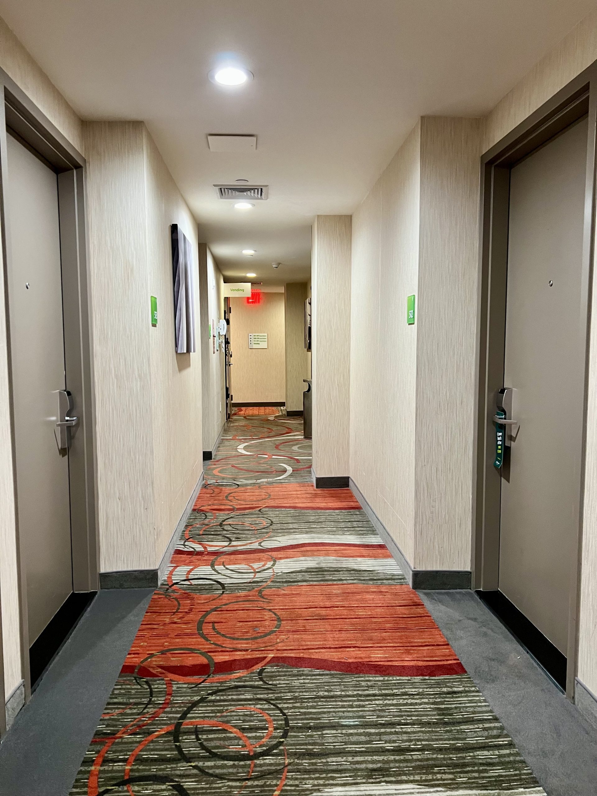 a hallway with colorful carpet and doors