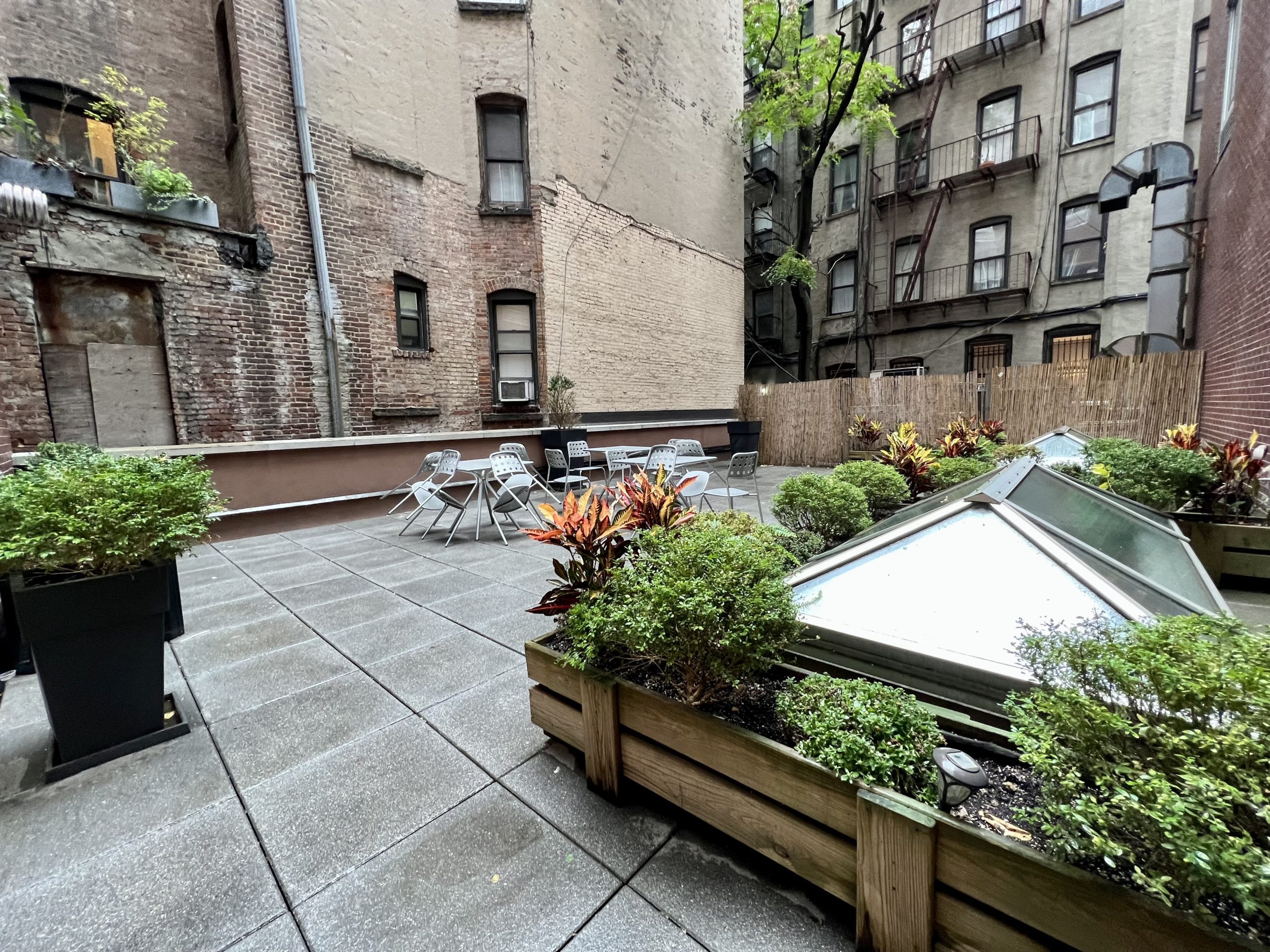 a patio with plants and High Line in the background