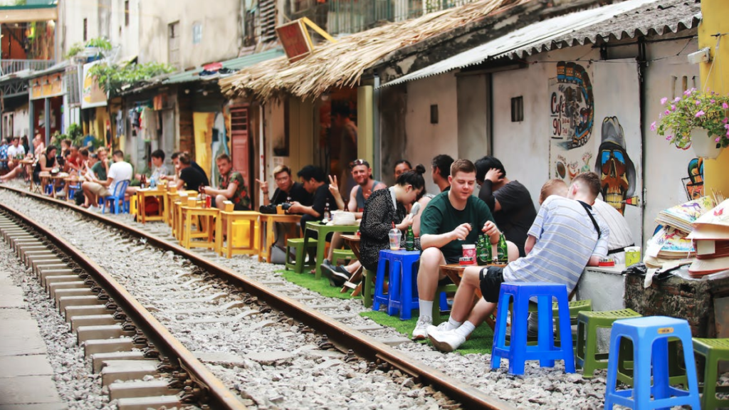 people sitting at tables on the tracks